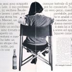 Una donna di schiena seduta su una sedia da regista. Accanto una bottiglia di Luxardo.