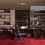 Un ufficio prestigioso con grande scrivania e libreria piena di faldoni.